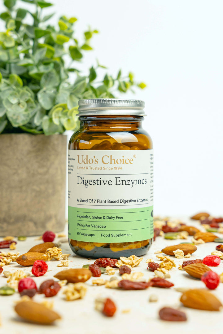 Udo's Choice Digestive Enzymes bottle with a background of nuts and berries