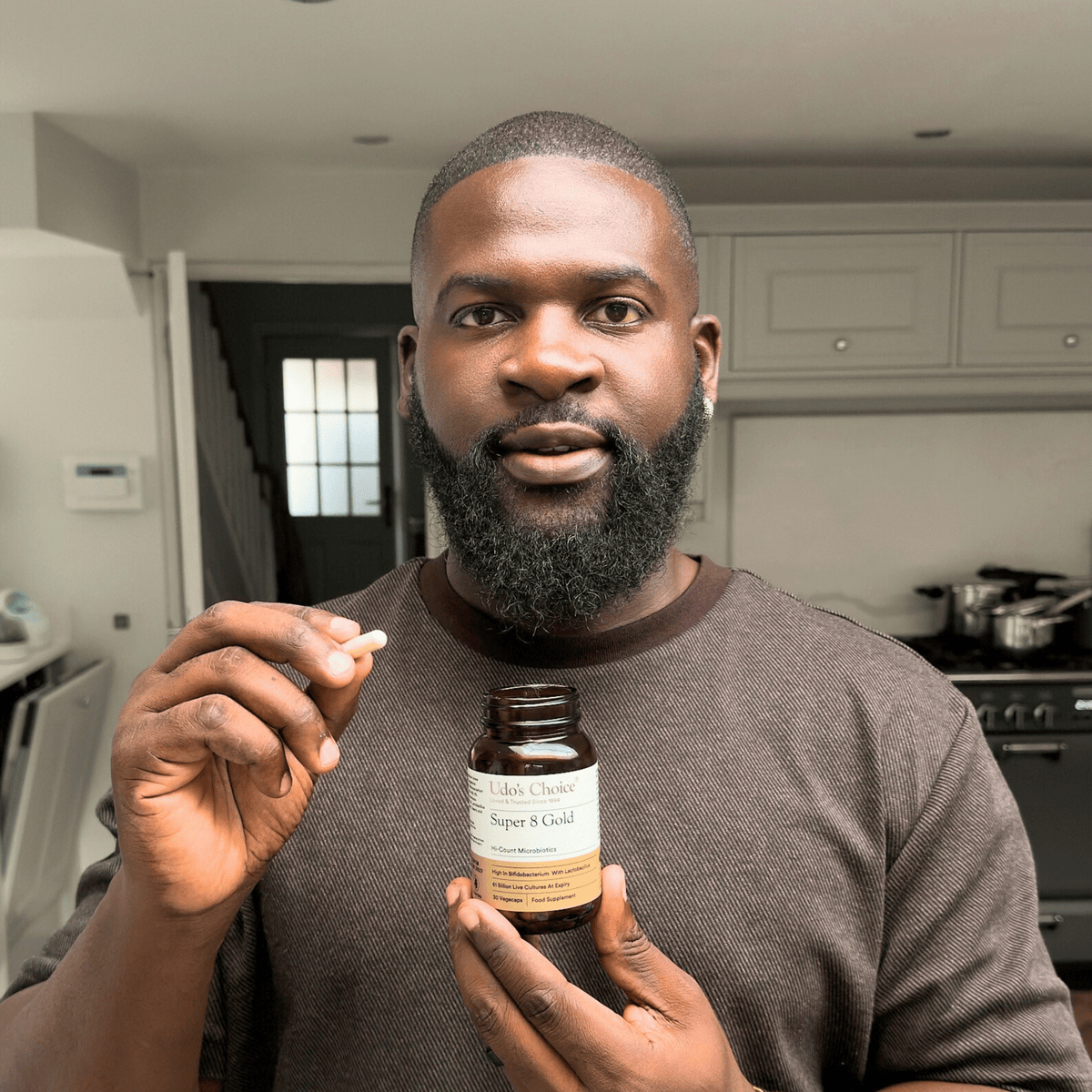 A man holding a bottle of Super 8 Gold